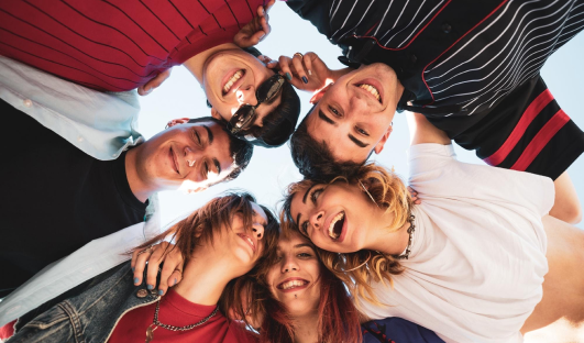 six youth in a circle with their arms around each other